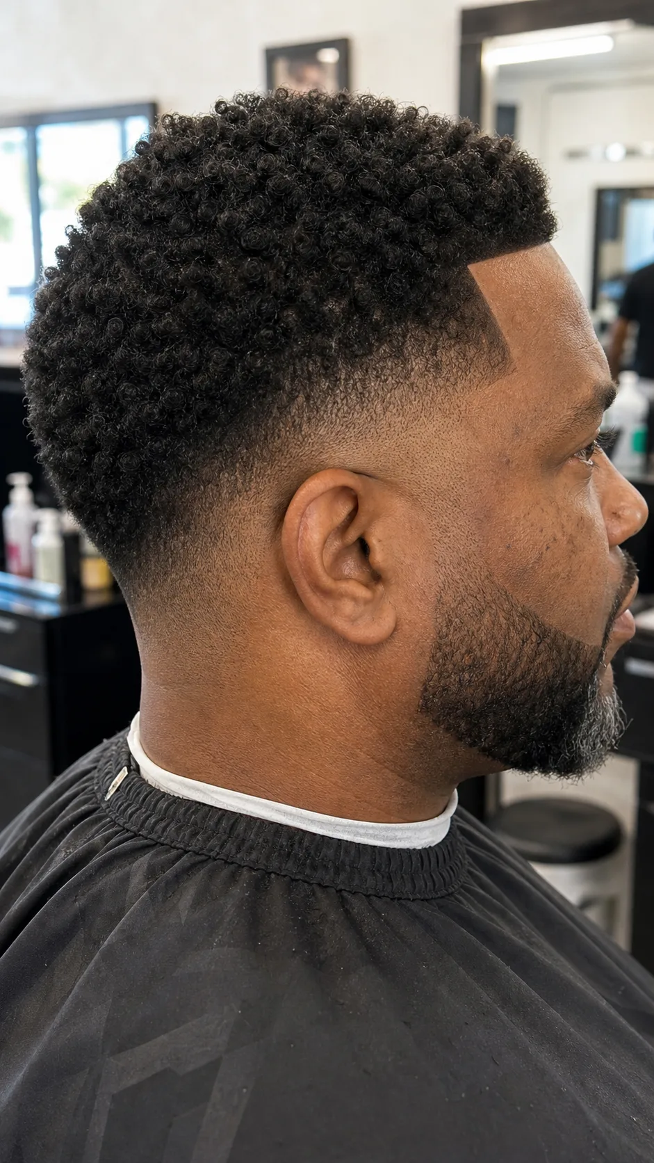 Afro curls mid skin fade with lineup photographed from the temple side